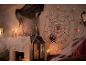 Halloween-Dekoration mit beleuchtetem Spinnennetz, Kerzen und Spinnweben.