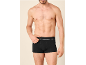 Oberkörperfreier Mann in schwarzen Boxershorts mit weißem Bund.