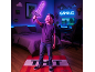 Ein Kind mit einem leuchtenden Spielzeugschwert in einem Gaming-Zimmer mit einem TNT-Teppich.