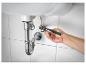 Hand benutzt Zange, um die Sanitärinstallation unter einem Waschbecken einzustellen.