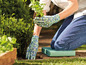 Gartenhandschuhe mit Blumendruck und Knieschutz beim Gärtnern.