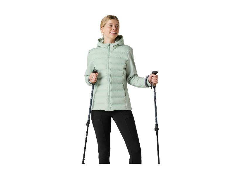 Frau in mintgrüner Steppjacke und schwarzen Leggings, hält CRIVIT Wanderstöcke.