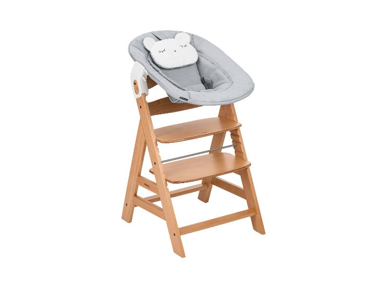 Hauck Holzhochstuhl mit grauer Babywippe und Bärenkissen.
