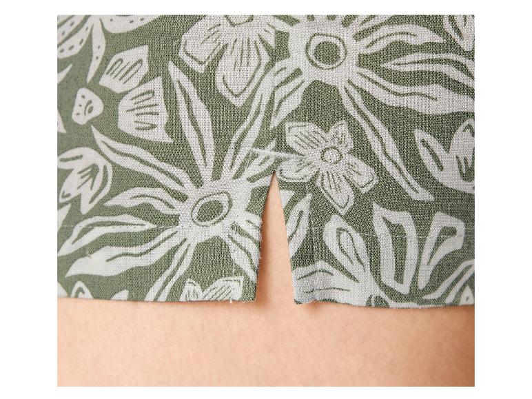 Grüner Stoff mit weißem Blumenmuster und einem Schlitz am Saum.