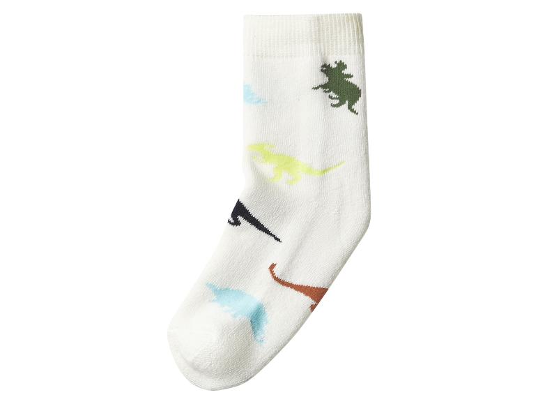 Weiße Kindersocken mit bunten Dinosaurier-Prints.
