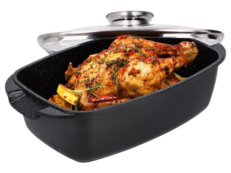 Gebratenes Hähnchen mit Kräutern und Zitrone in einer schwarzen Bratpfanne mit Glasdeckel
