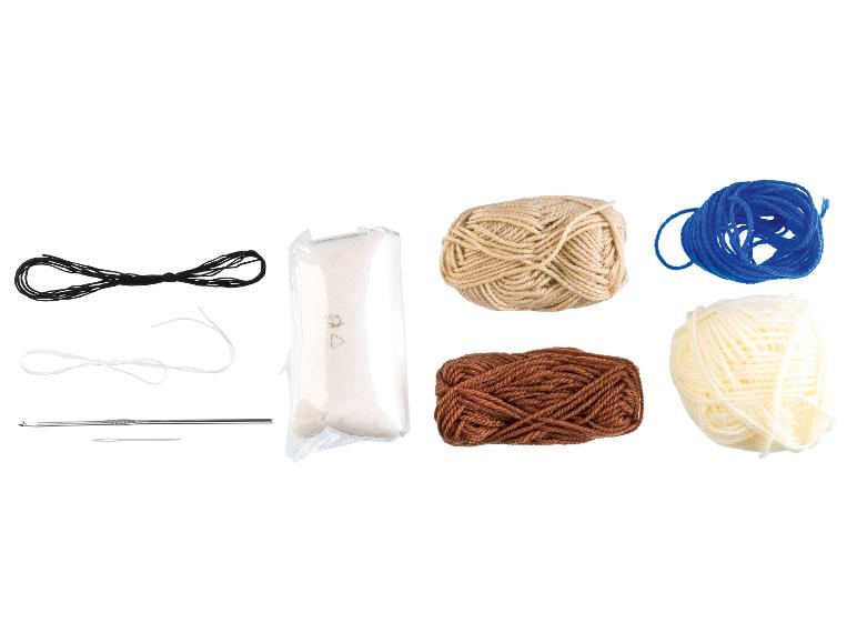 Häkelset mit Garn in verschiedenen Farben, Füllung und Zubehör.