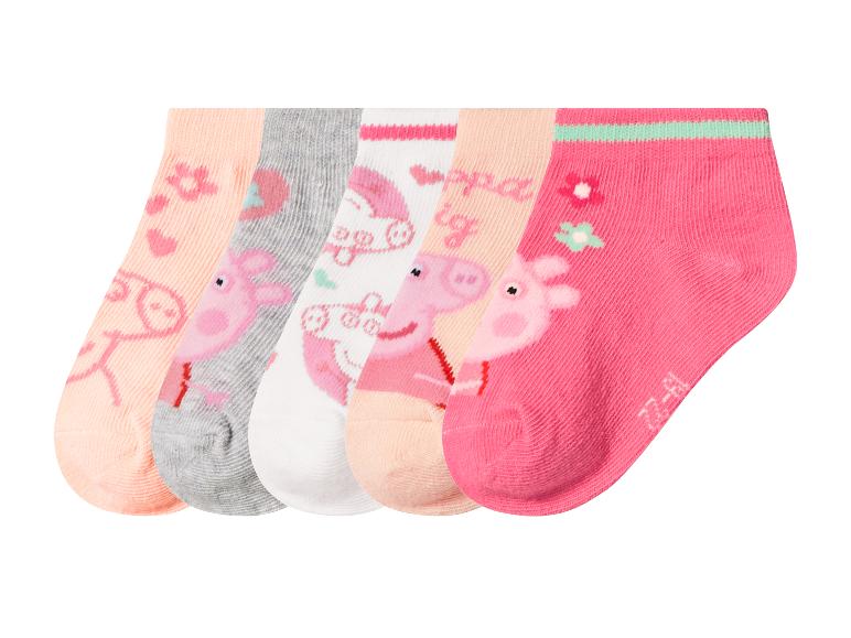 Fünf Paar Kindersocken mit Schweinchen- und Blumenmotiven in Rosa, Grau und Weiß.