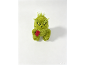 Kleine grüne Grinch-Plüschfigur mit einem roten Schal auf weißem Hintergrund.