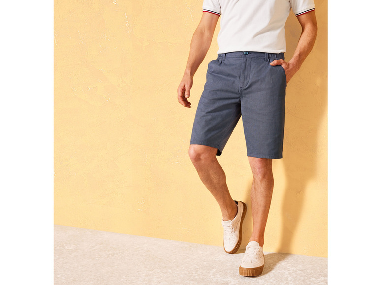 Mann in blauen Shorts und weißen Schuhen