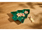 Weihnachtsplätzchen mit festlicher Dekoration auf einem grünen Baumteller.