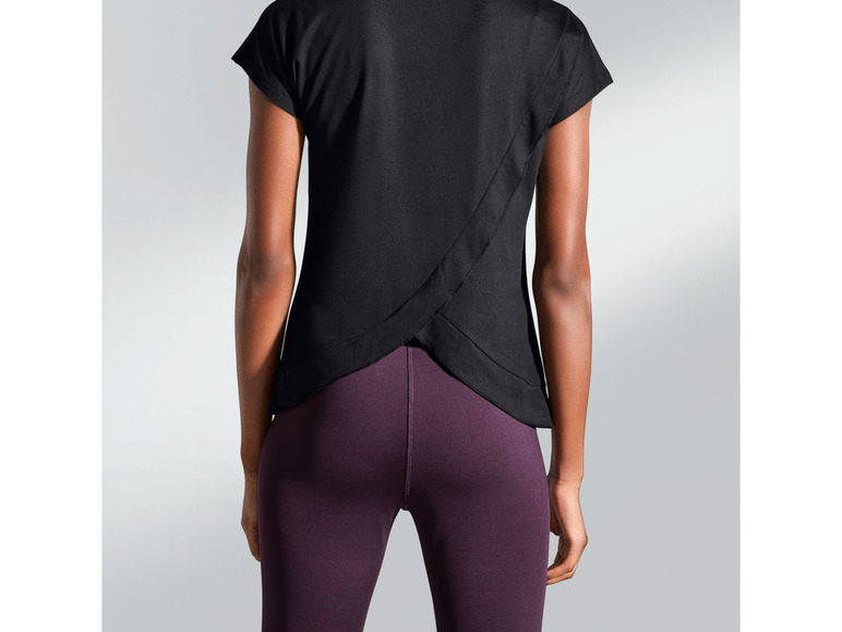 Schwarzes Shirt mit Kreuzrücken und lila Leggings.