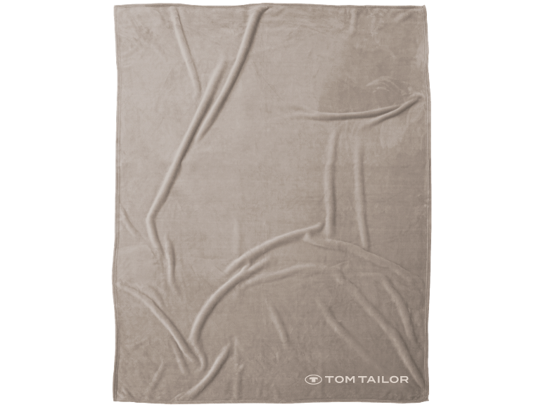 Beige Fleecedecke mit Falten und Markenlogo in der unteren rechten Ecke.
