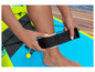 Eine Person befestigt ein schwarzes Fußband an einem aufblasbaren Paddleboard.