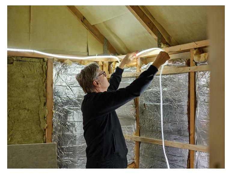Mann installiert LIVARNO® Leuchtschlauch »The Renovator« Lichtschlauch auf dem Dachboden.