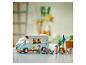 Lego Friends Set mit Wohnmobil, drei Figuren, Picknicktisch, Bäumen und einem Fahrrad.