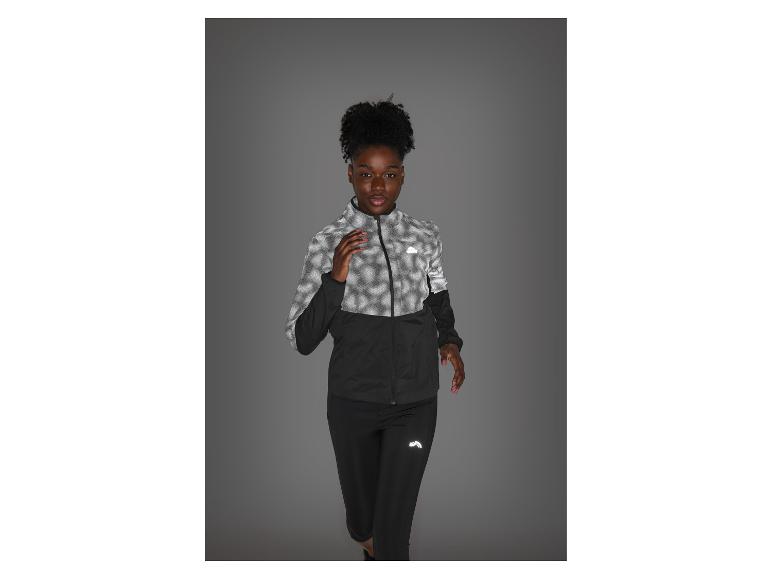 Frau in reflektierender schwarz-grauer Sportkleidung, bereit zum Laufen.