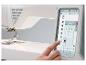 Nähmaschine mit Touchscreen, der Stichoptionen anzeigt, und einer Hand, die ihn bedient.