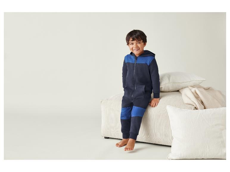 Ein Junge trägt eine blaue Kapuzenjacke und Hose.