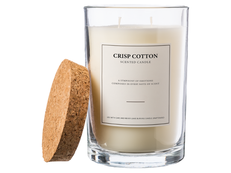 Eine Duftkerze im Glas mit Korkdeckel, beschriftet mit „Crisp Cotton“.