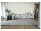 Modernes Wohnzimmer mit grauem Modulsofa, grauem Teppich und minimalistischer Dekoration.
