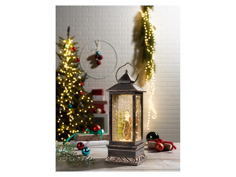 Weihnachtslaterne mit Weihnachtsmann und glitzerndem Schnee, umgeben von Weihnachtsbaum und Geschenken.