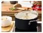 Ein KitchenAid Topf mit Suppe auf einem Kochfeld, mit einer Schüssel Suppe daneben.