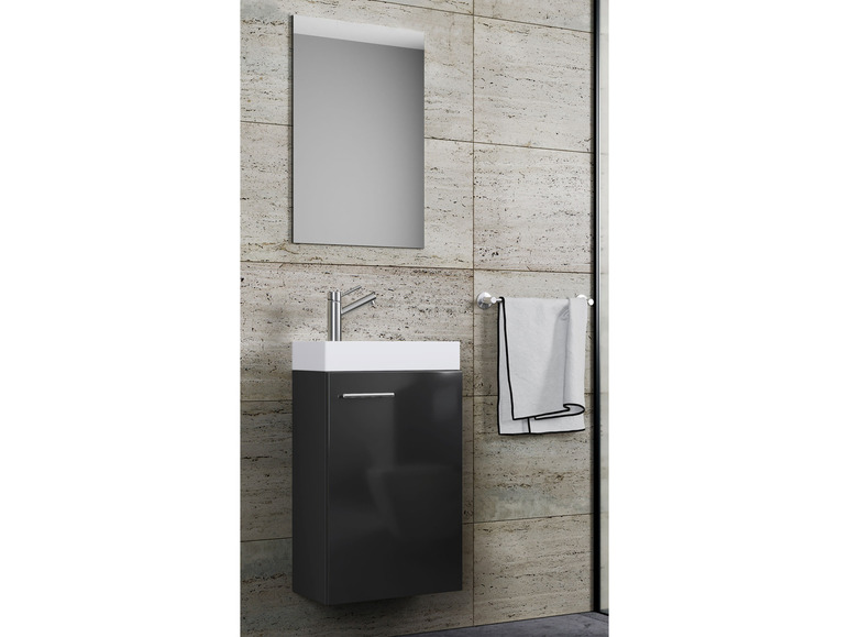 Ein Badezimmer mit einem schwarzen Waschbeckenunterschrank, einem Spiegel und einem Handtuchhalter.