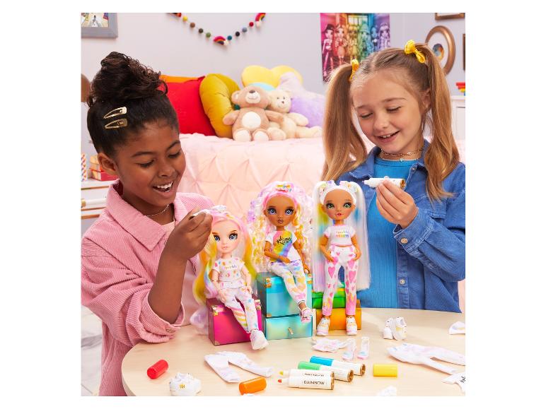 Zwei Mädchen spielen mit Rainbow High Puppen und Zubehör.