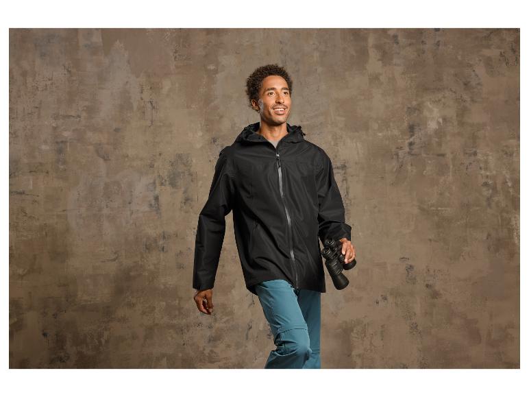 Ein Mann trägt eine schwarze Jacke und ein Fernglas.