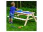 Kleinkind spielt mit einem Sand- und Wasser-Picknicktisch aus Holz im Garten.