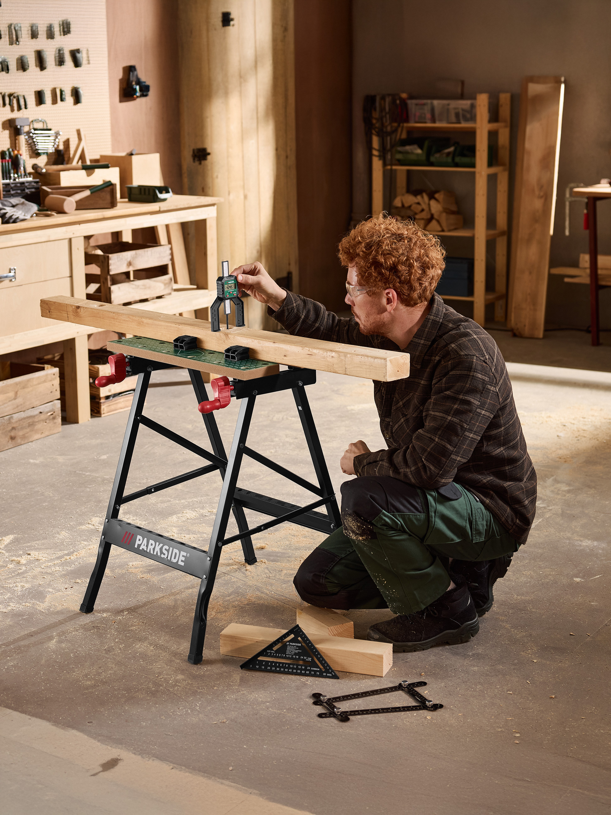 Mann misst Holz auf einer schwarzen PARKSIDE Werkbank mit einem digitalen Tiefenmesser.