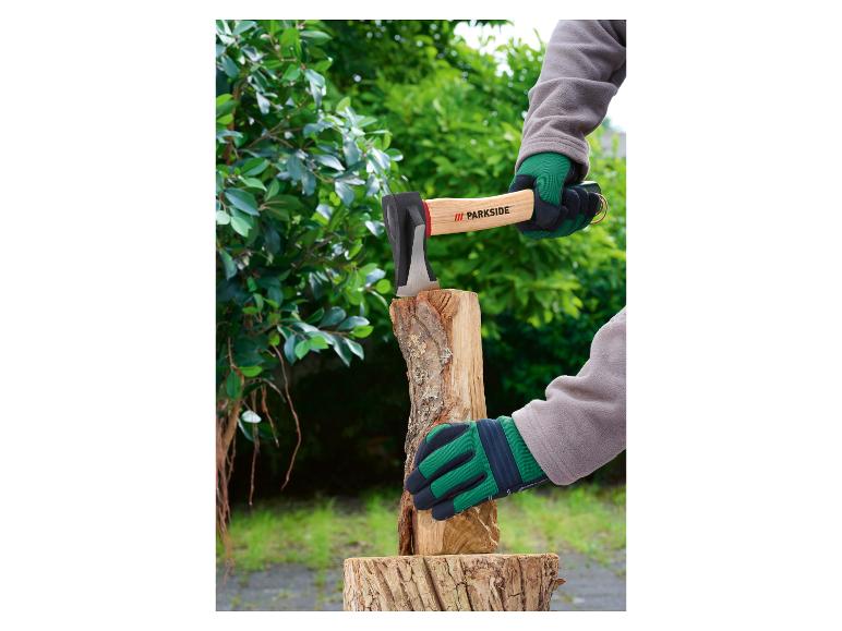 Hände spalten Holz mit einer Axt im Freien.