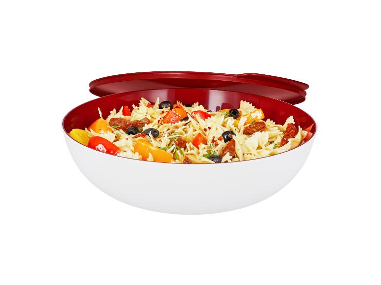 Nudelsalat mit Paprika, Oliven und getrockneten Tomaten in einer weiß-roten Schüssel.