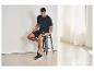 Mann in CRIVIT Herren-Funktionsshorts 2-in-1 sitzt und benutzt eine Massagepistole.