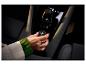 Frau im Auto berührt ein rundes Gerät mit grünen Lichtern.