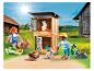 Playmobil-Figuren von Kindern, die Kaninchen in einem Stall auf einem Bauernhof füttern.