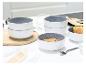 Gestapelte und einzelne Keramikschalen mit Müsli, Obst und Wasser auf einem weißen Tisch.