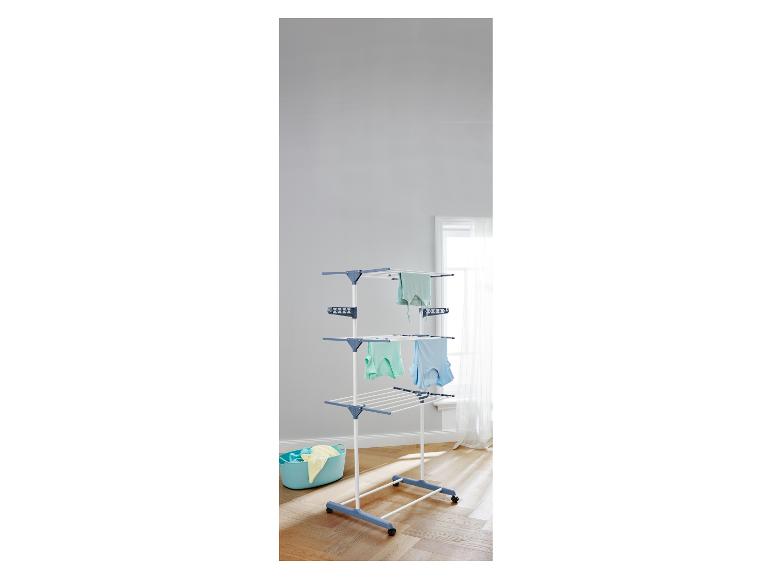 Weiß-blauer Wäscheständer mit drei Ebenen und einem blauen Wäschekorb.