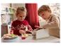 Zwei Kinder spielen mit einem Holz-Küchenset, inklusive Toaster.