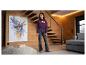 Mädchen in einem bordeauxroten Hoodie mit „PARIS AMOUR CLUB“-Aufschrift und dunklen Jeans, stehend in einem modernen Wohnzimmer.