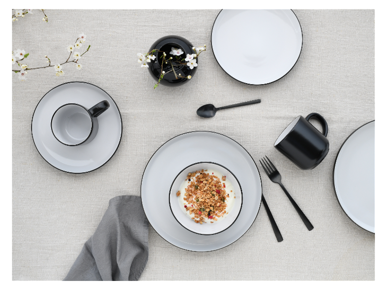Granola-Schale, schwarze und weiße Tassen und Teller.