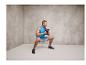 Ein Mann macht Kniebeugen mit einer Kettlebell in einem Fitnessstudio.