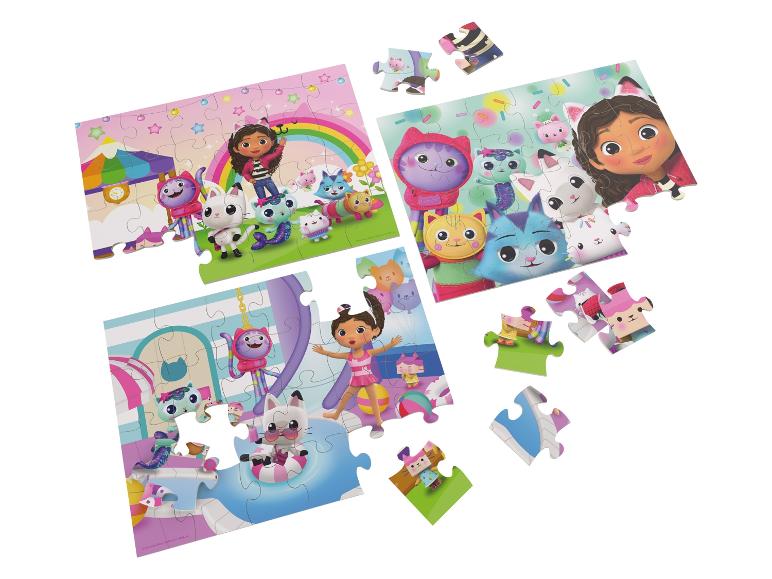 Drei Puzzles mit einem Mädchen und Katzenfiguren, teilweise zusammengebaut, teilweise zerlegt.
