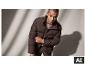 Mann in brauner Steppjacke und beigem Premium-Pullover aus Kaschmir-Seiden-Mix. [KI-generiertes Bild]
