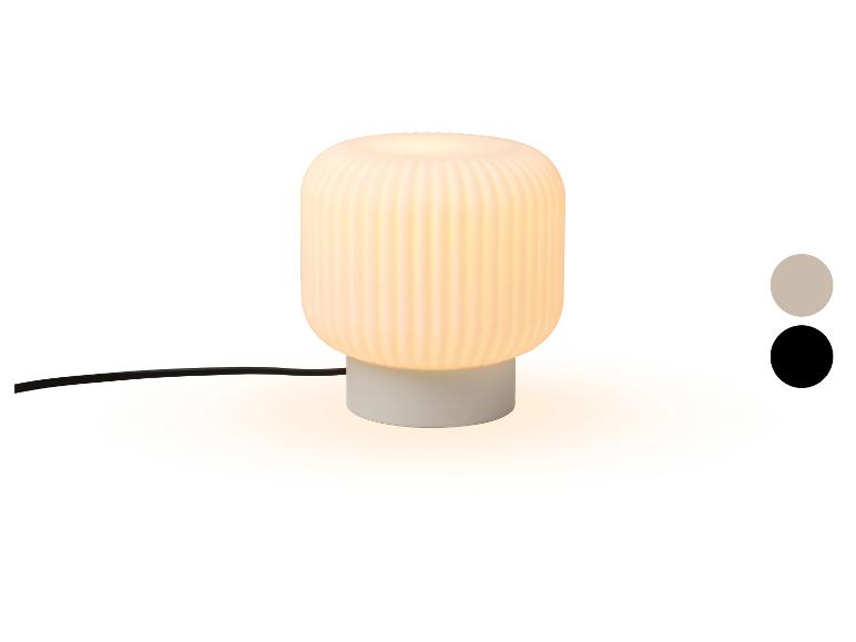 Tischlampe mit geripptem weißem Schirm und grauem Sockel, mit Farbmustern.