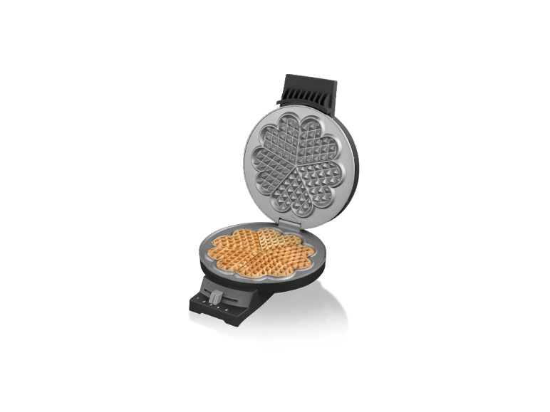 Offenes Waffeleisen mit herzförmigen Waffeln auf der unteren Platte.
