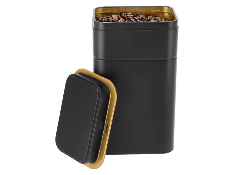 Schwarze Metallkaffeedose mit goldener Innenseite und Deckel, gefüllt mit Kaffeebohnen.