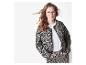 Frau trägt eine Leopardenmuster-Jacke und -Hose, ein weißes T-Shirt und eine Brille.