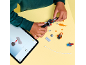 Kind baut Spielzeugfahrzeug mit Bausteinen, Anweisungen auf einem Tablet folgend.